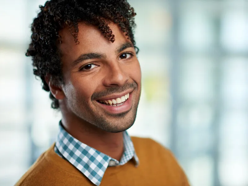 A close-up of a person looking calmly to the side in soft natural light.