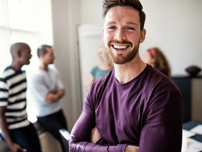 A young person laughing in a bright office space.