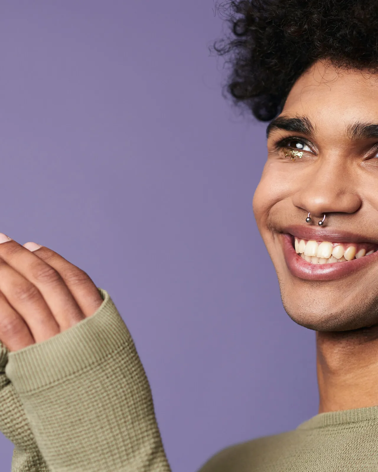 A young person smiling softly outdoors in afternoon light, looking ahead with calm confidence.